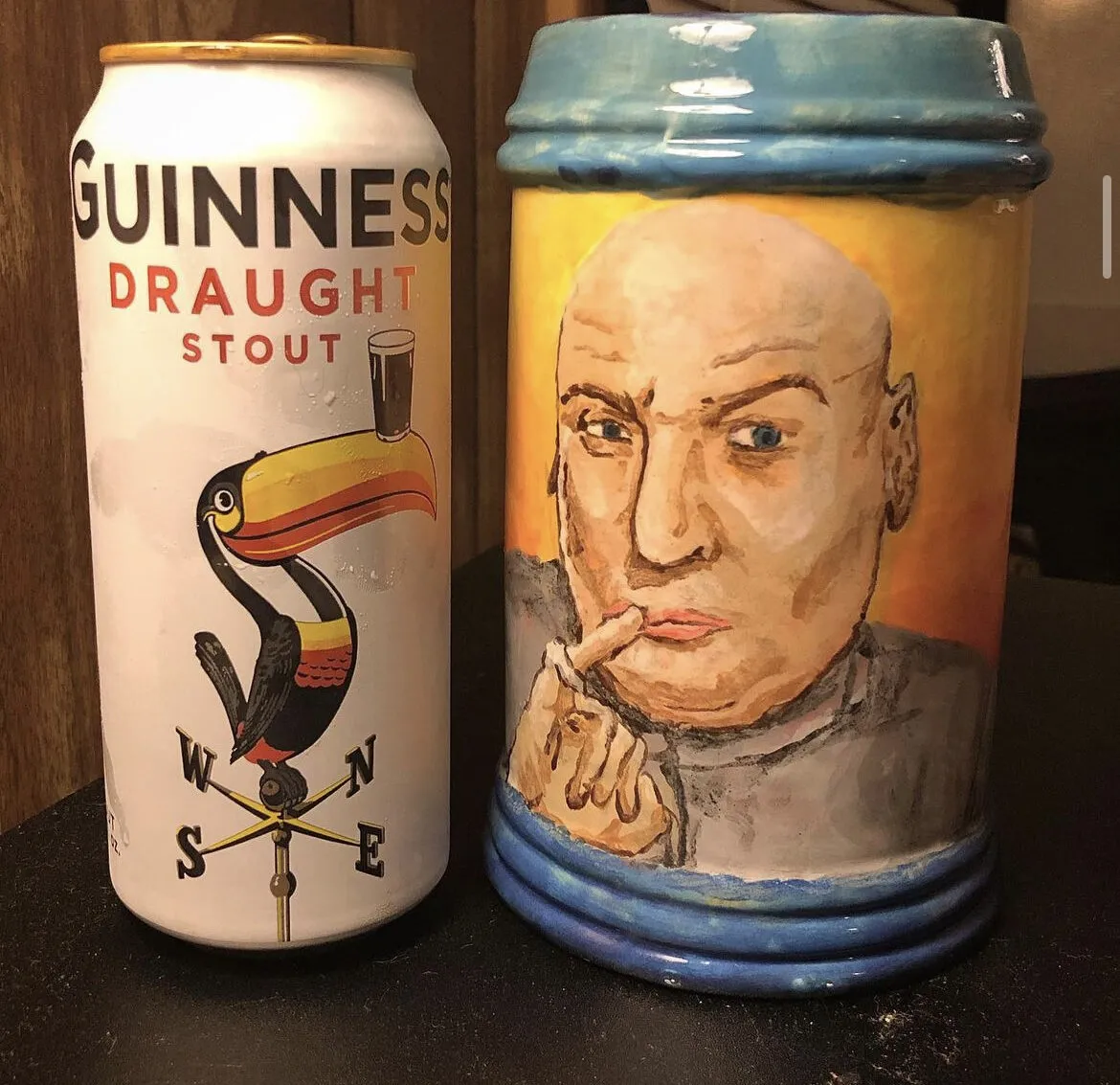 A stein painted with Dr. Evil beside a can