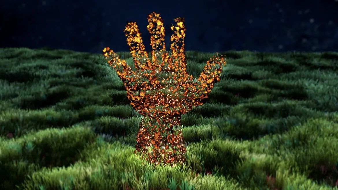 A hand made of orange leaves in a dark field