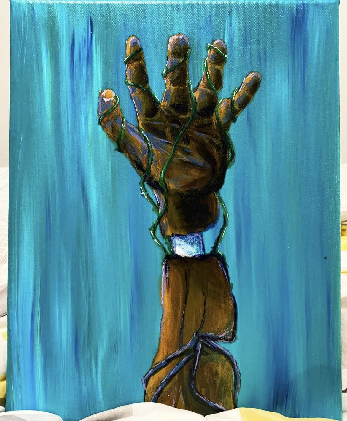 A brown hand raised against blue