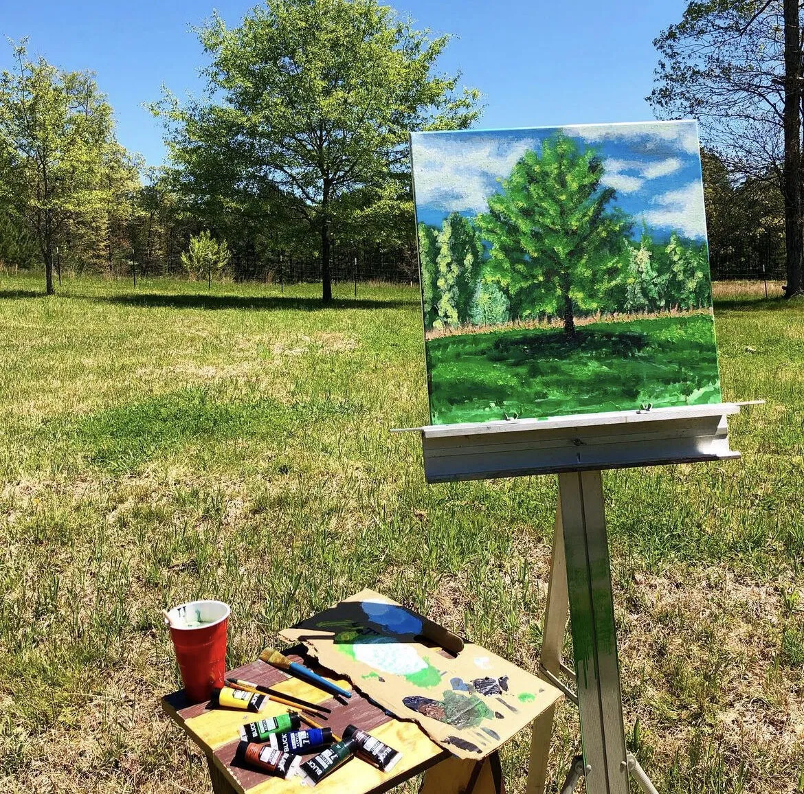 The painting on its easel in the field